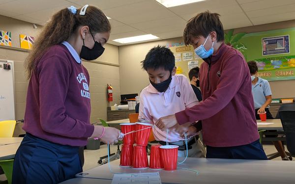 Columbus Academy Students working on a science project with cups