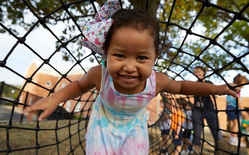 Young Academy student playing in ropes on playground